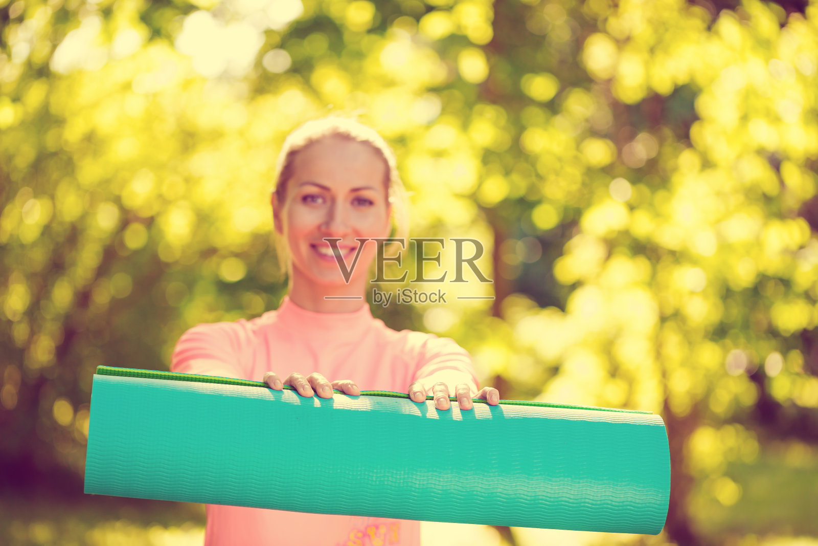 健身的女人手里拿着蓝色的瑜伽垫照片摄影图片