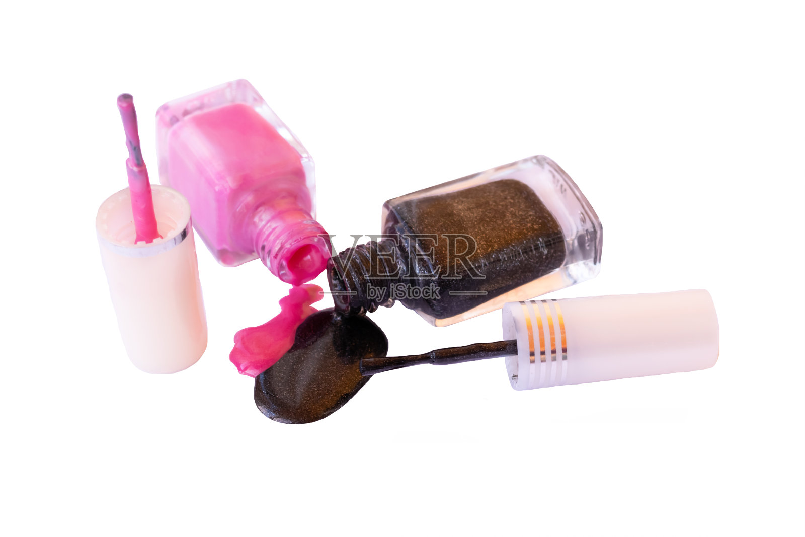 近距离观看两个玻璃瓶倒出粉红色和深灰色的指甲油照片摄影图片