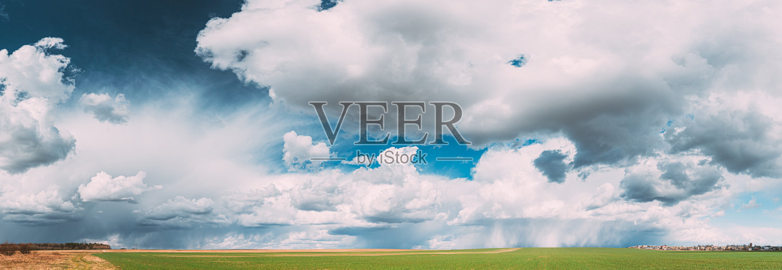 春日晴雨的乡村田园草地景观。美丽的天空与雨云在地平线上。农业和天气预报概念。全景照片摄影图片