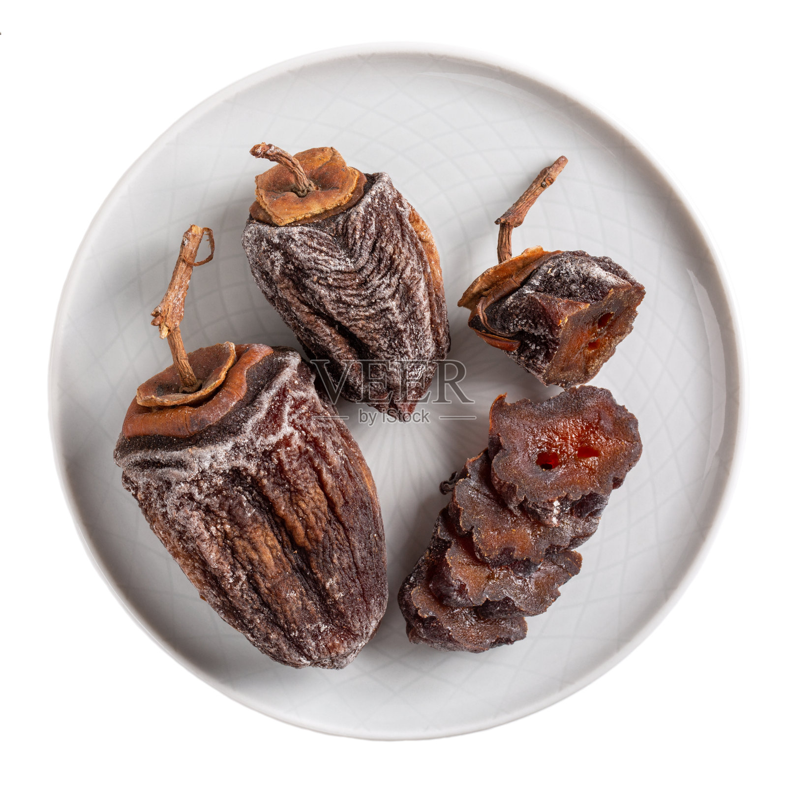 干柿子放在灰色盘子上，单独放在白色盘子上。前视图。照片摄影图片