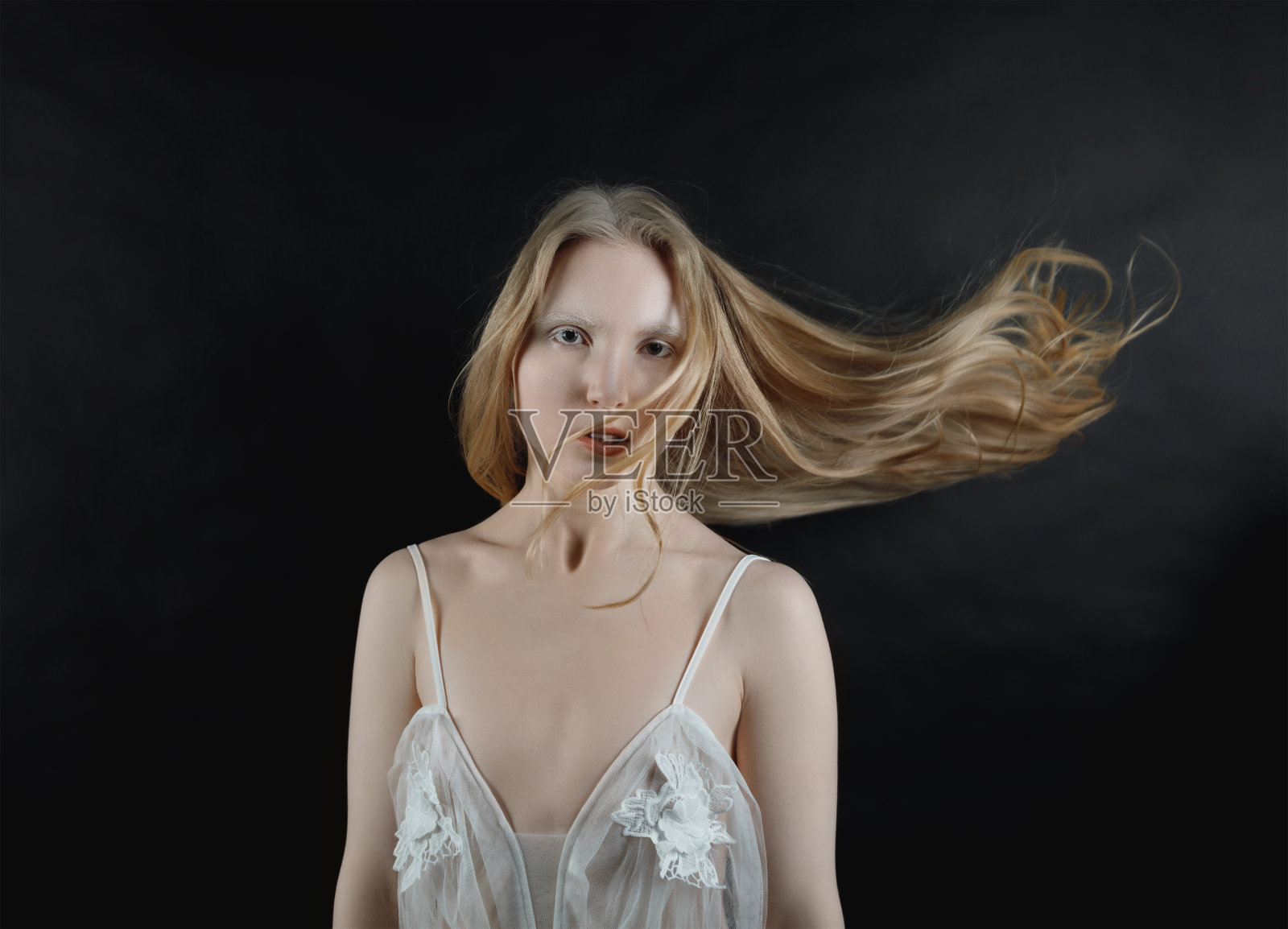 一个年轻的金发女孩的概念肖像，她的头发飞扬照片摄影图片