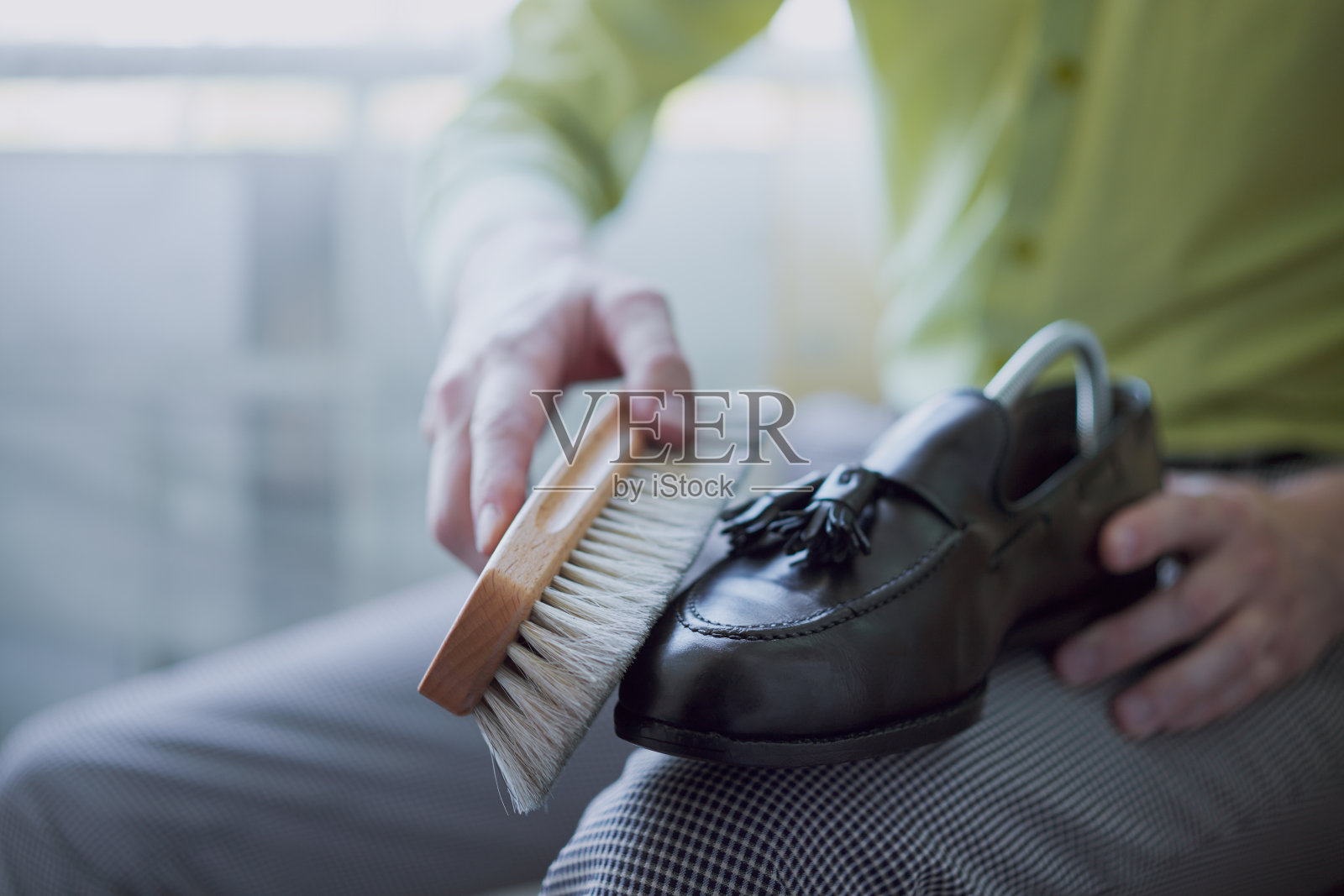 年轻的白人正在修理旧皮鞋。照片摄影图片