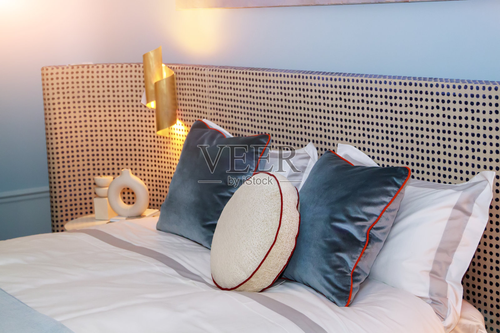 特写的新毛毯装饰枕头，织物点缀床头板在卧室样品模型的酒店或公寓照片摄影图片