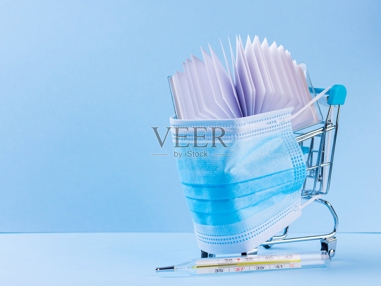 装有医用防护口罩的购物车。温度计和笔记本放在购物车上。在超市安全购物。检疫的概念。本空间照片摄影图片