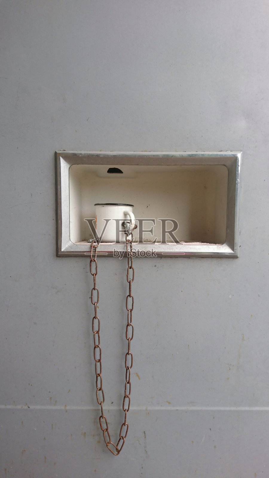 旧的汽水机。有链子的铁杯子。照片摄影图片