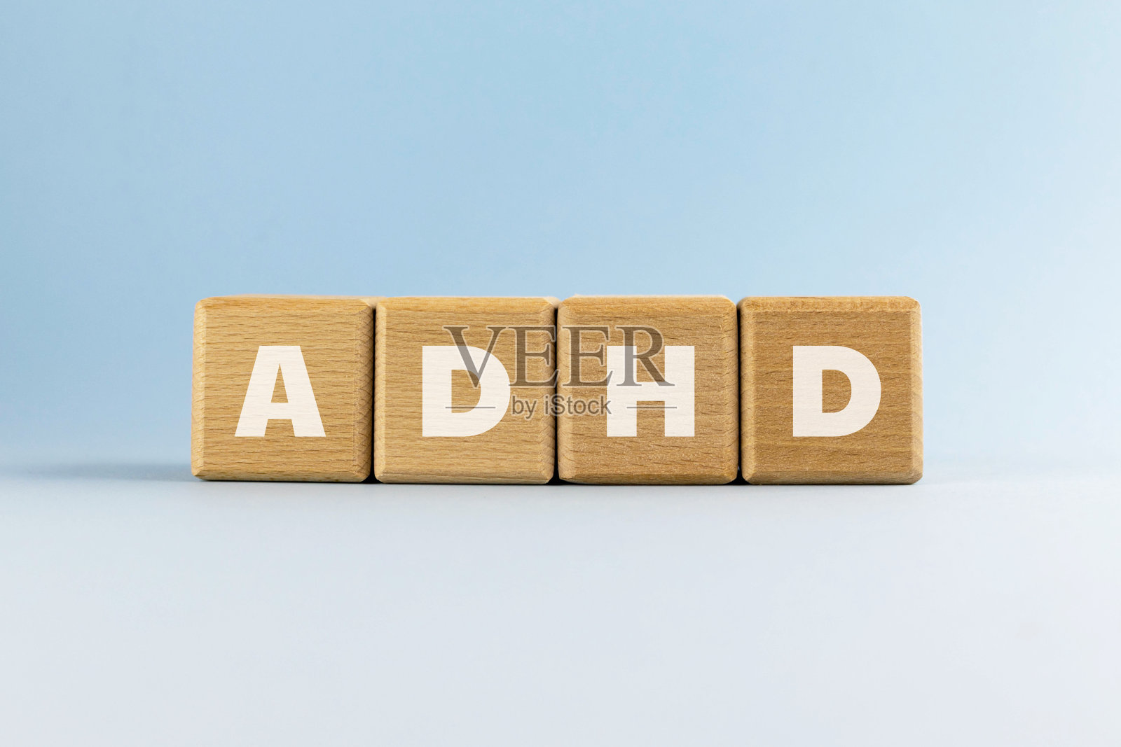 注意力缺陷多动障碍（ADHD），浅蓝色背景上的木块文字缩写照片摄影图片