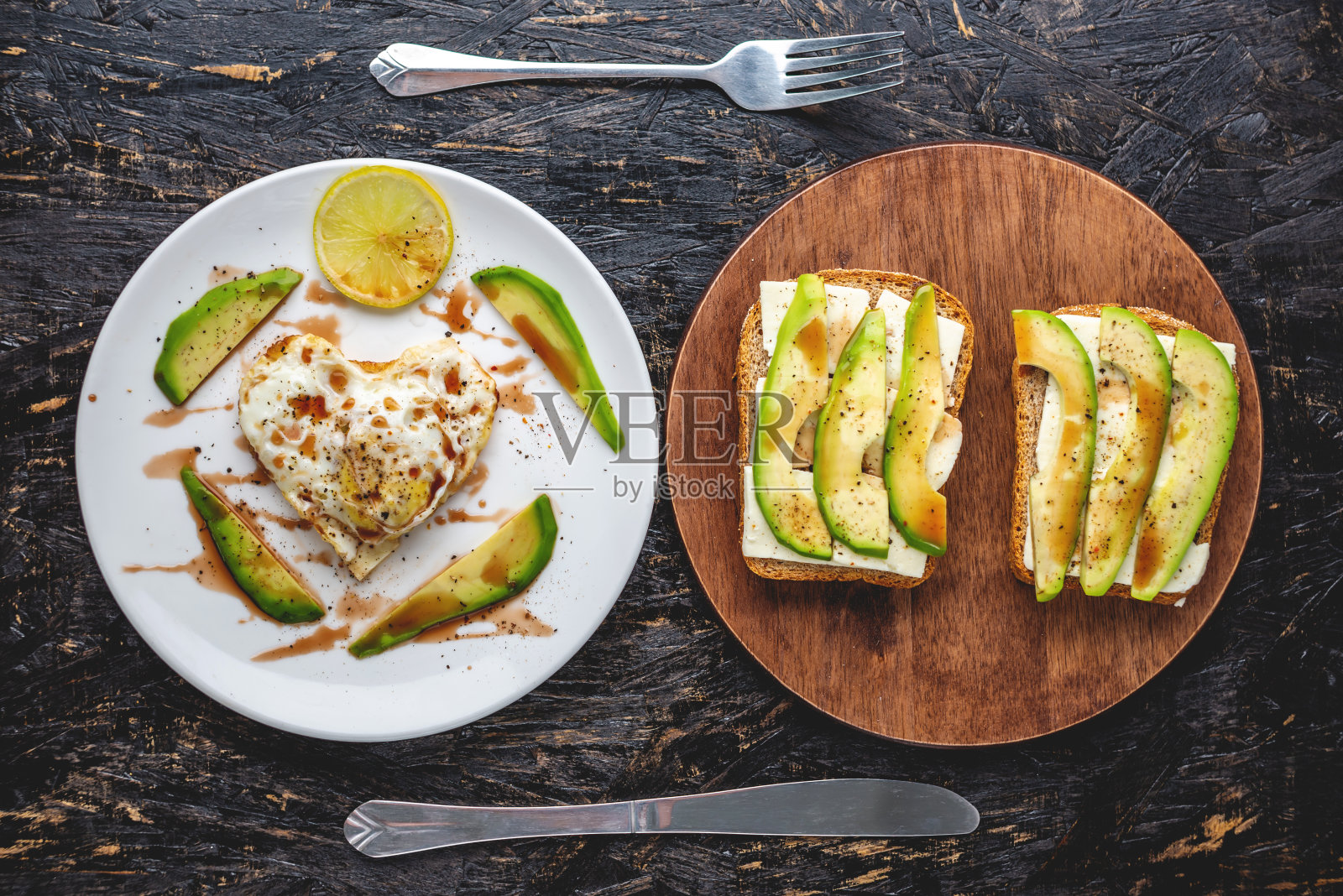 美丽、健康、浪漫的早餐:白色盘子上的心形煎蛋，还有牛油果三明治照片摄影图片