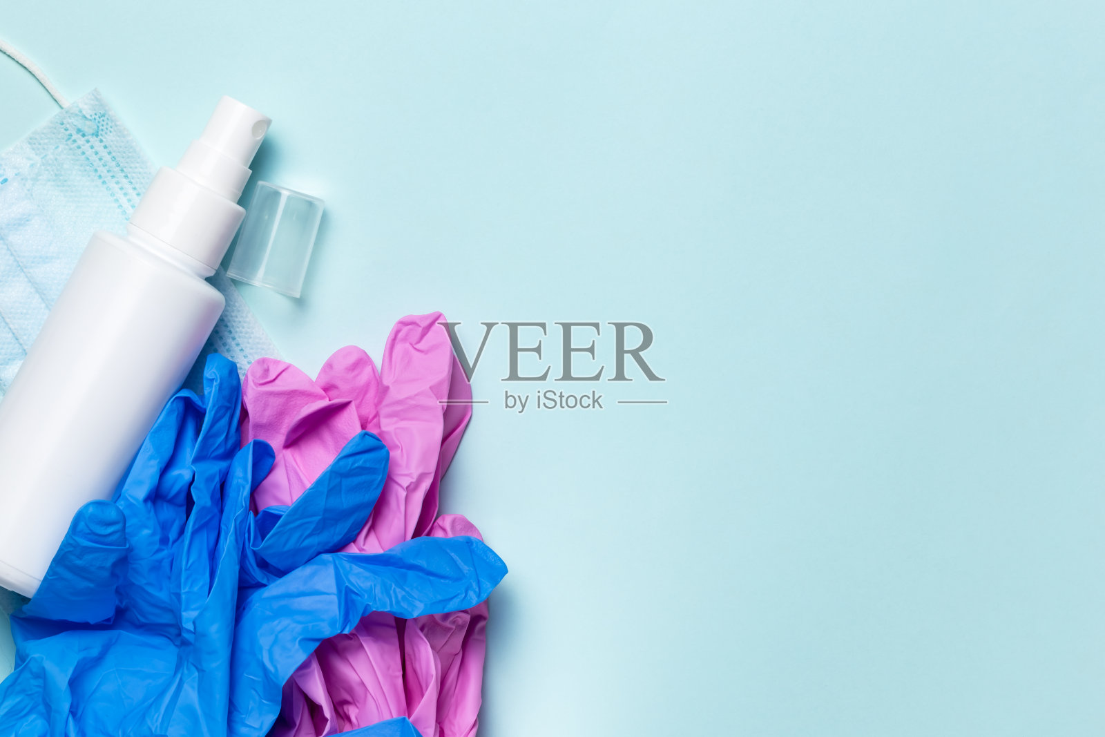 大流行Covid-19冠状病毒。个人防护用品，用于在疫情期间防范病毒和细菌的医用口罩、消毒洗手液、蓝色背景橡胶手套照片摄影图片