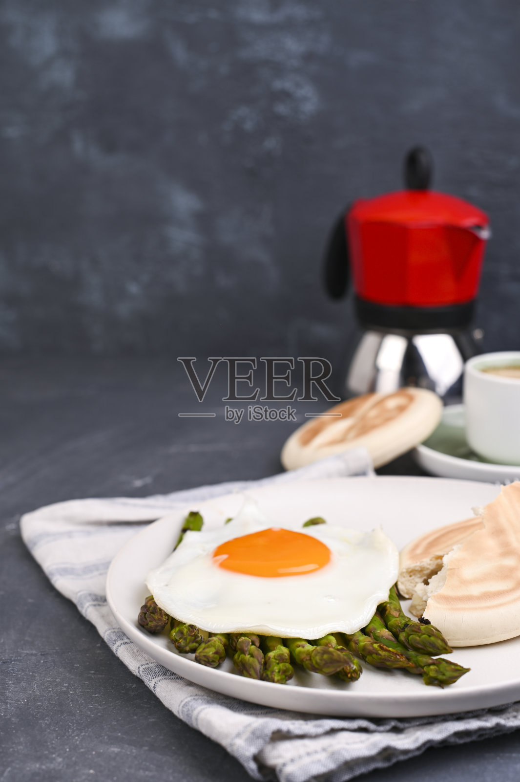 健康的早餐。煎蛋，芦笋，面包和芳香的咖啡在灰色的背景。文本的自由空间。软的焦点。照片摄影图片