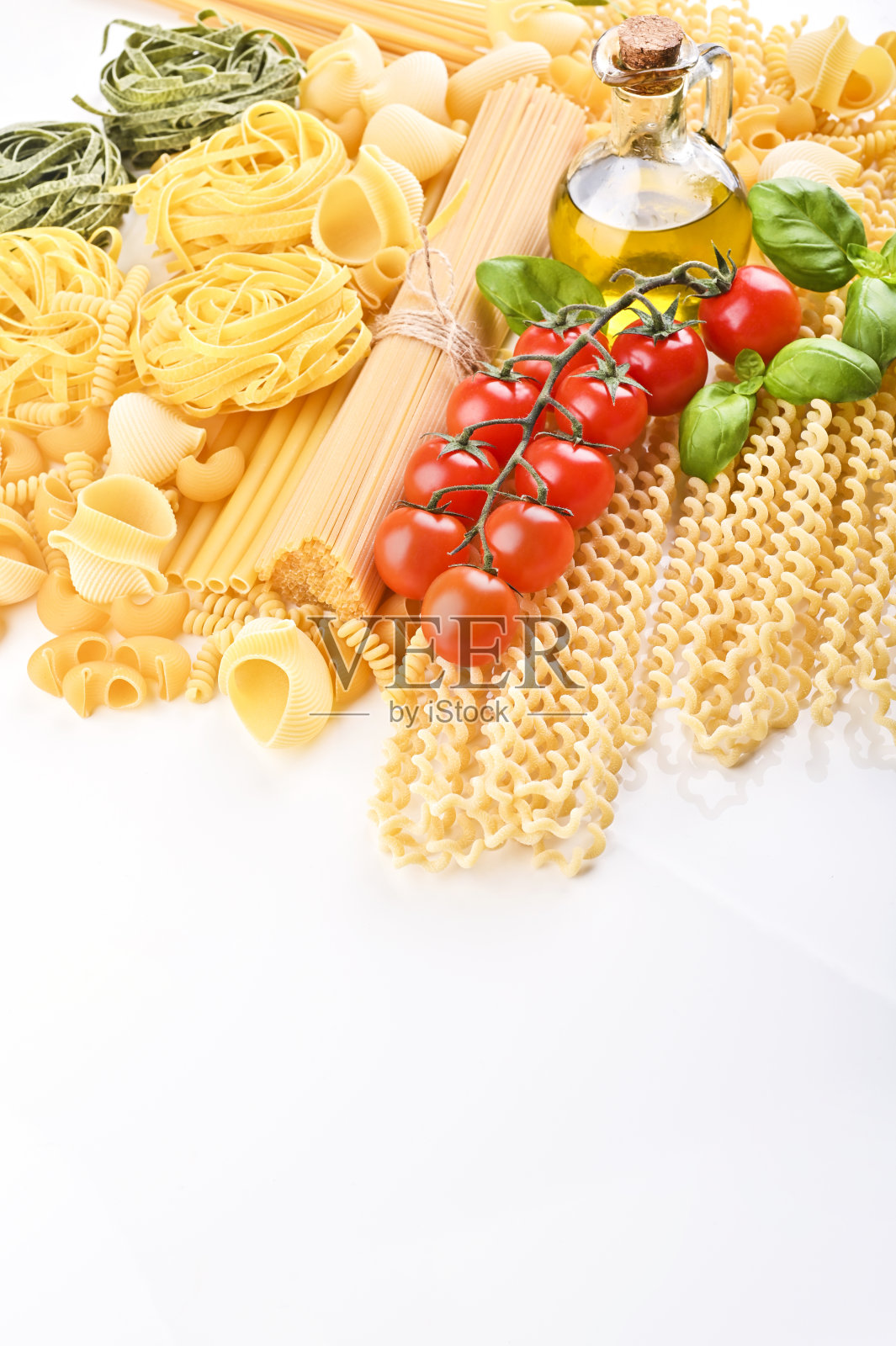 一组不同类型的意大利面。意大利面配上新鲜的西红柿、罗勒和橄榄油，背景是简陋的乡村，俯视图，边框。有烹饪原料的意大利面。意大利菜照片摄影图片