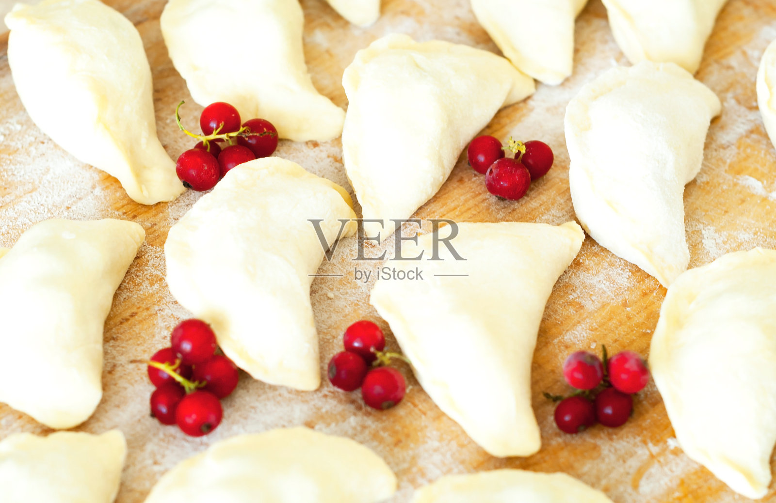 自制饺子或Pierogi在木背景和面粉。传统的乌克兰或波兰食物。照片摄影图片