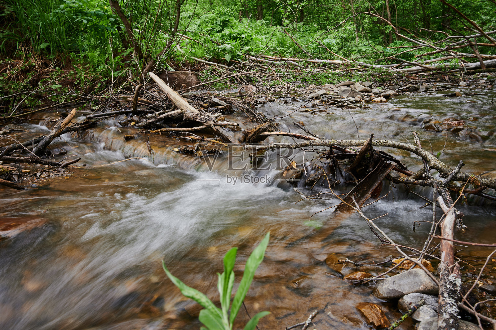 美丽的自然瀑布在一个小湖里。照片摄影图片