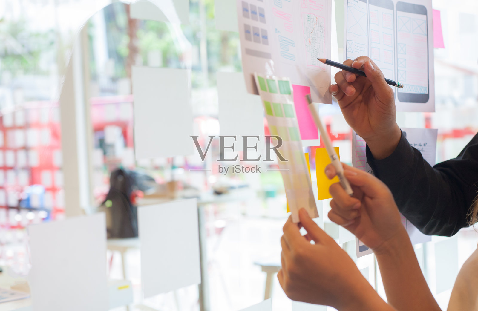 年轻的设计师一起规划和设计手机上的旅行应用程序。照片摄影图片