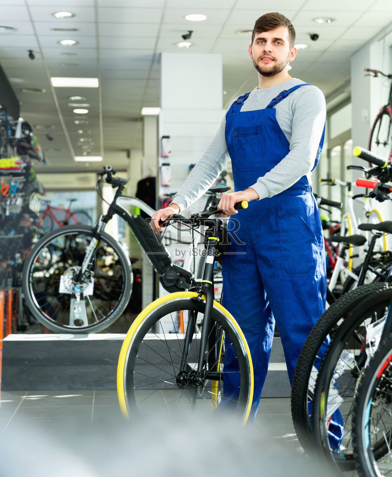 一个年轻修理工站在自行车商店附近的肖像照片摄影图片