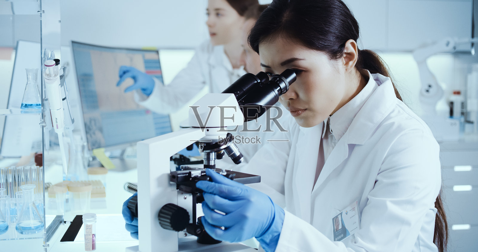 laboratorr遗传研究。亚洲女医生使用显微镜，研究伙伴背景照片摄影图片