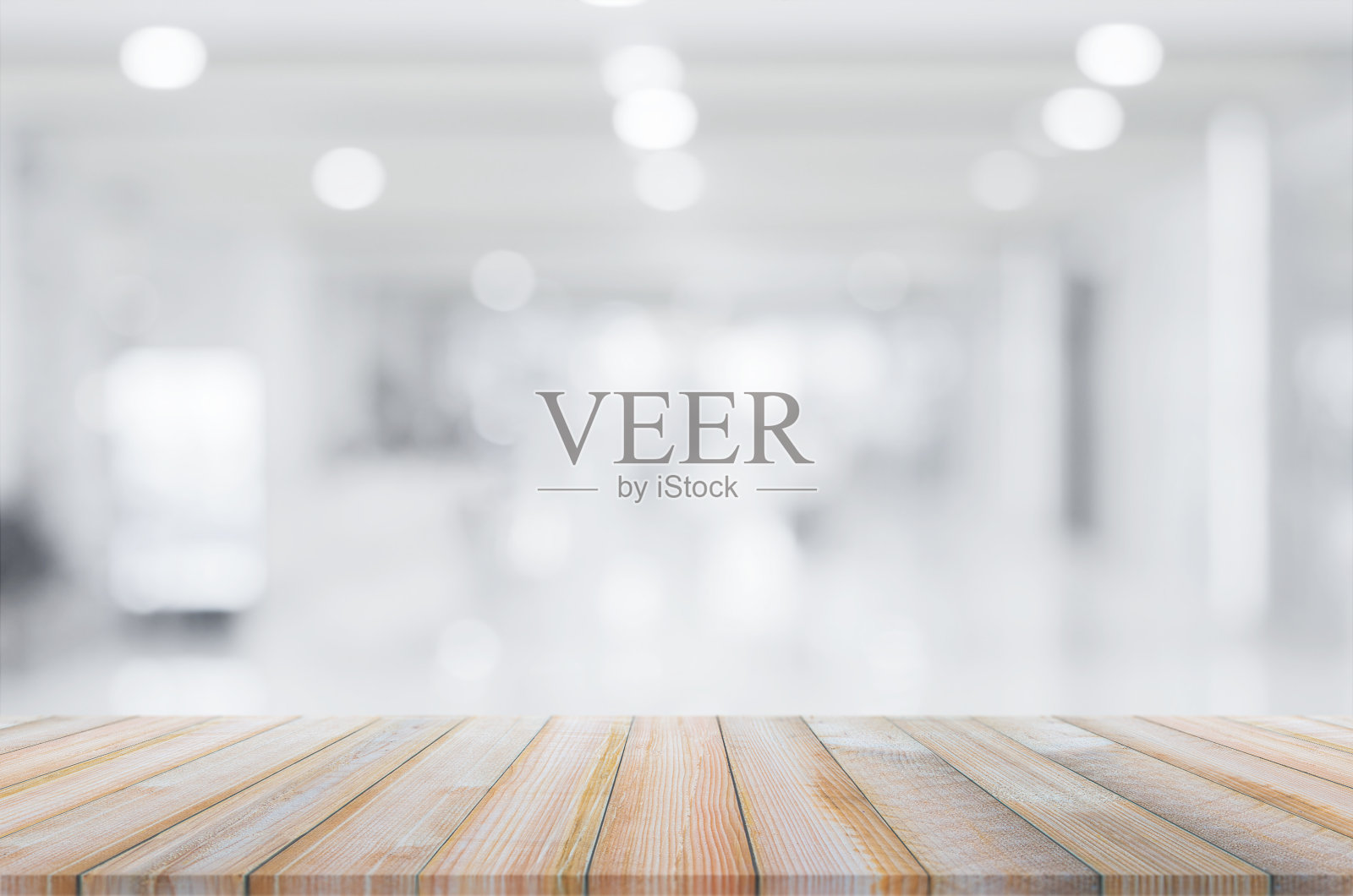 木桌以抽象模糊的背景在商场灯光室内用于展示蒙太奇产品模拟设计。照片摄影图片