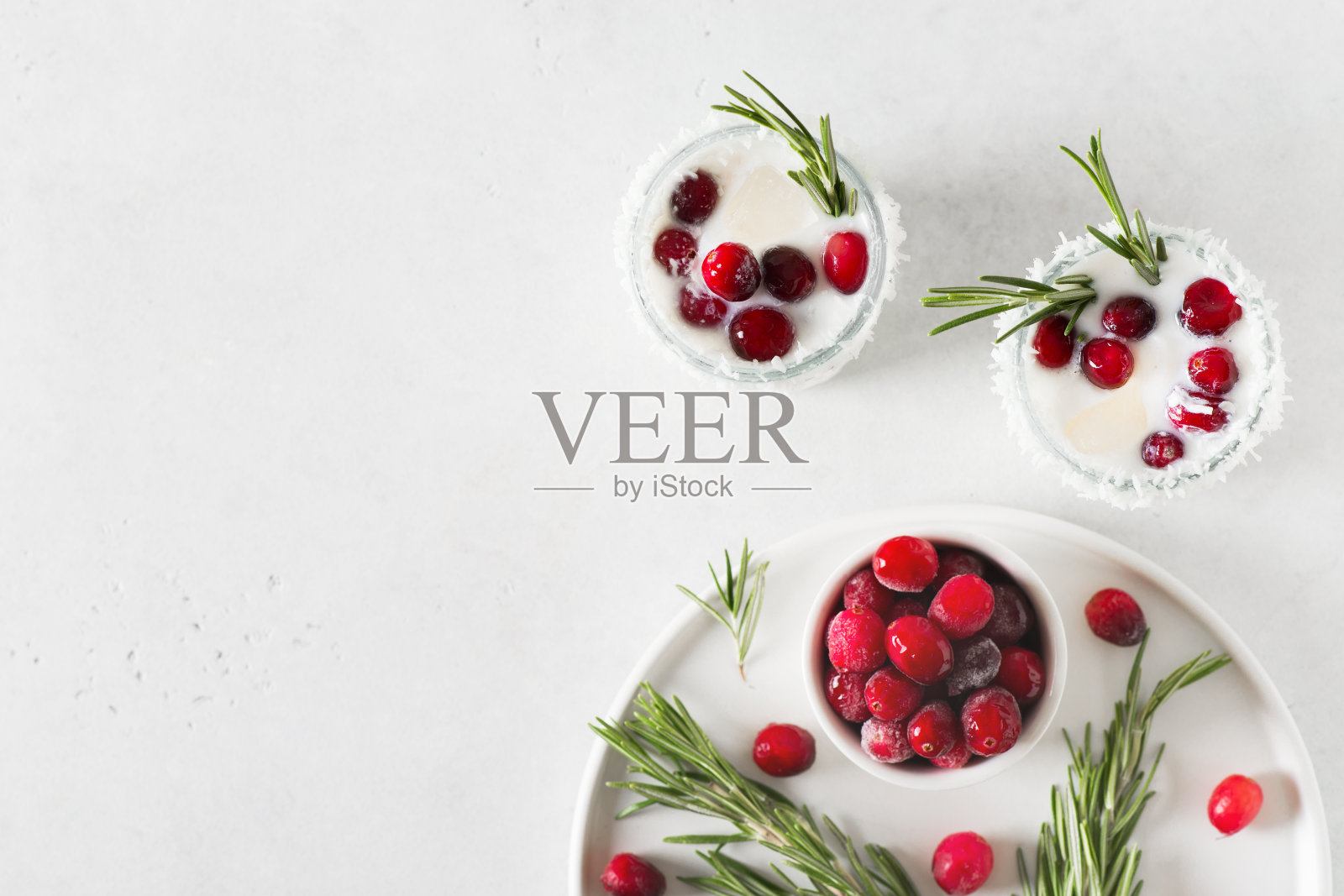 白色鸡尾酒，含椰奶、蔓越莓和迷迭香酒精或鸡尾酒，白色背景照片摄影图片