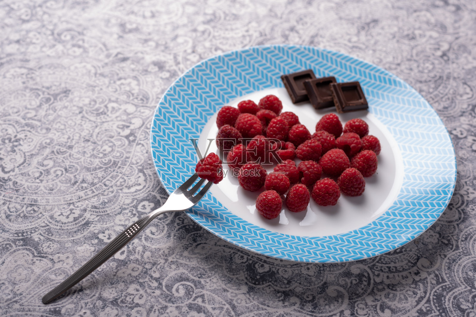 覆盆子心和巧克力的菜肴。情人节照片摄影图片