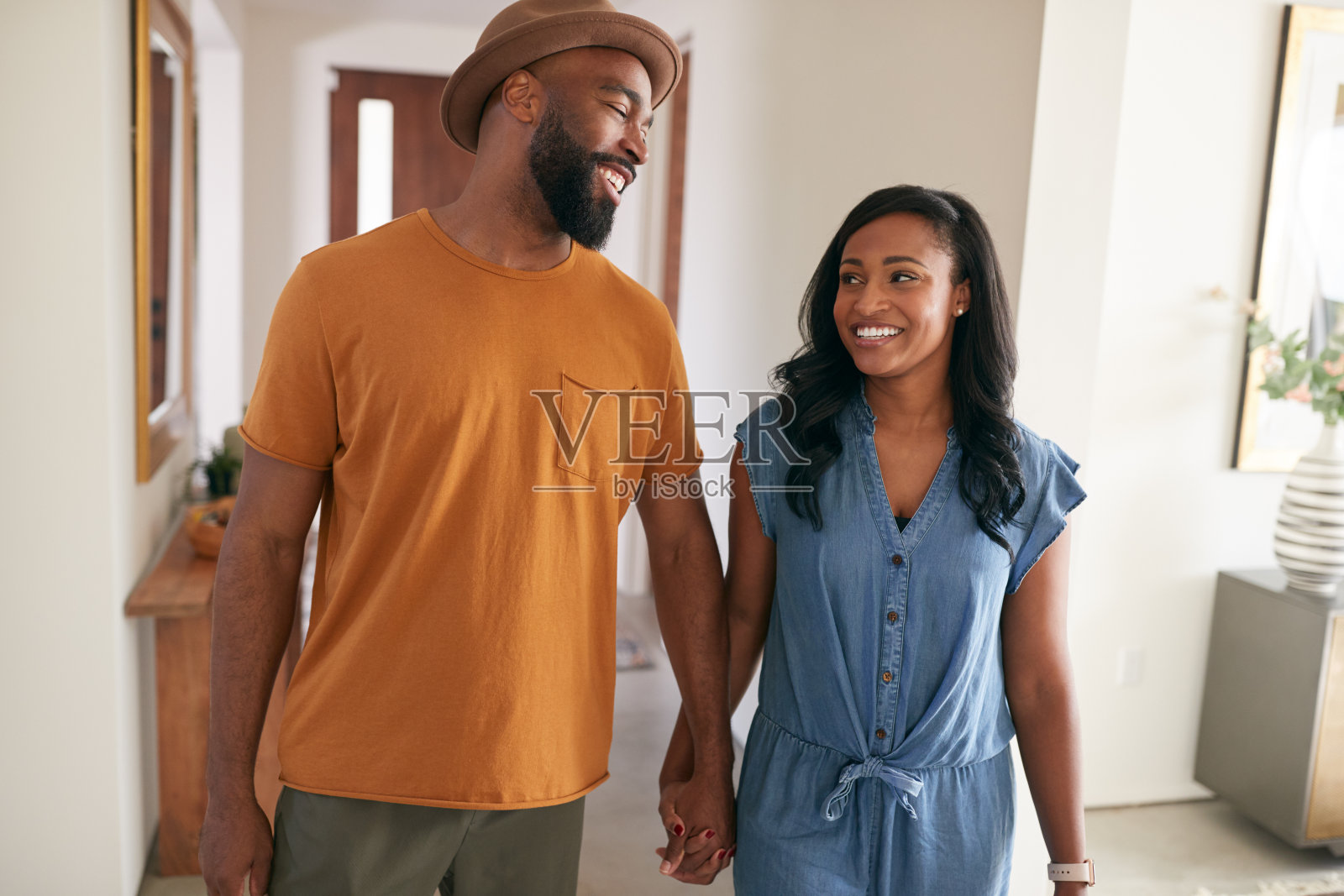 爱的非裔美国夫妇手牵着手走进家里的大厅照片摄影图片