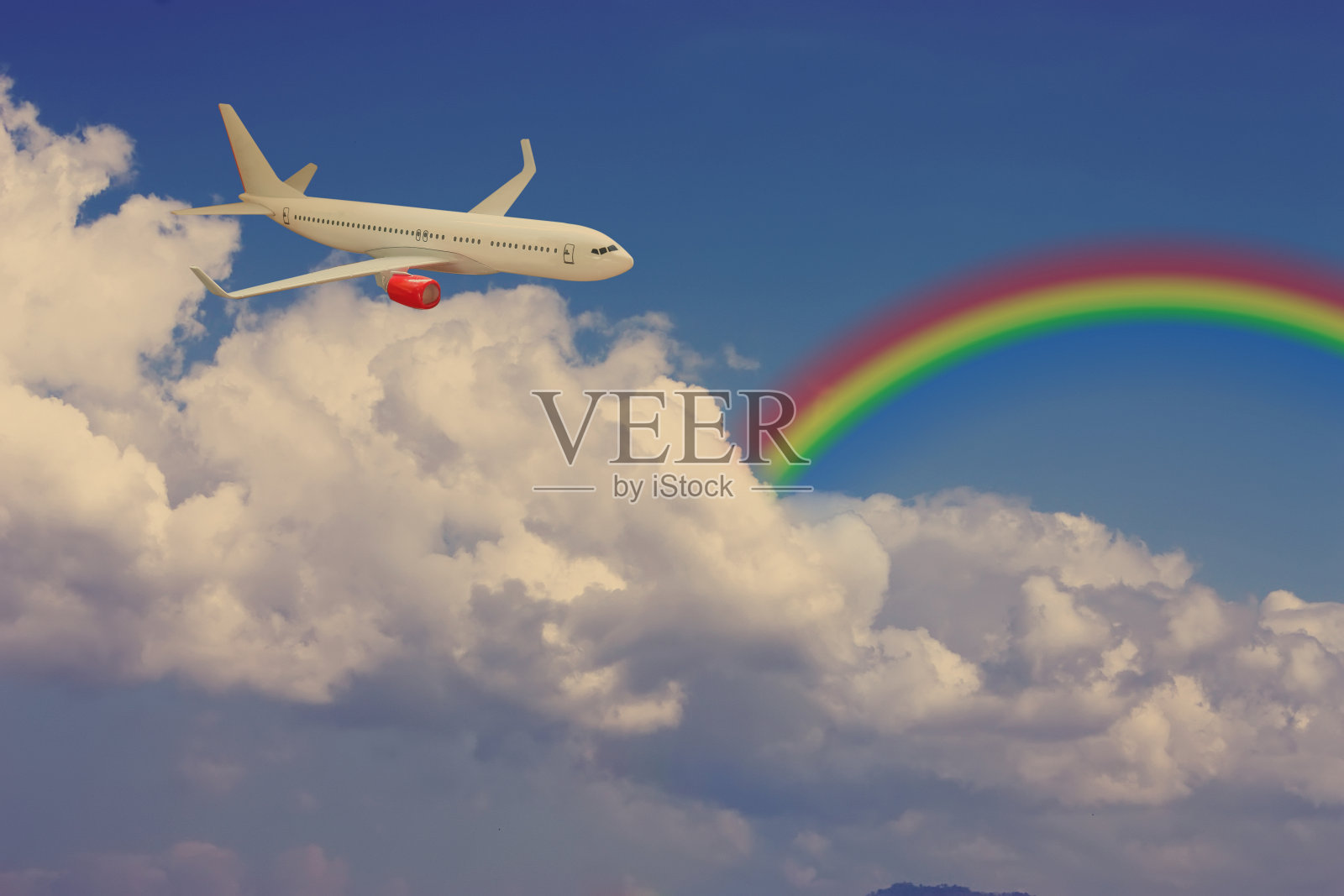飞机飞过蓝天，白云和彩虹。照片摄影图片
