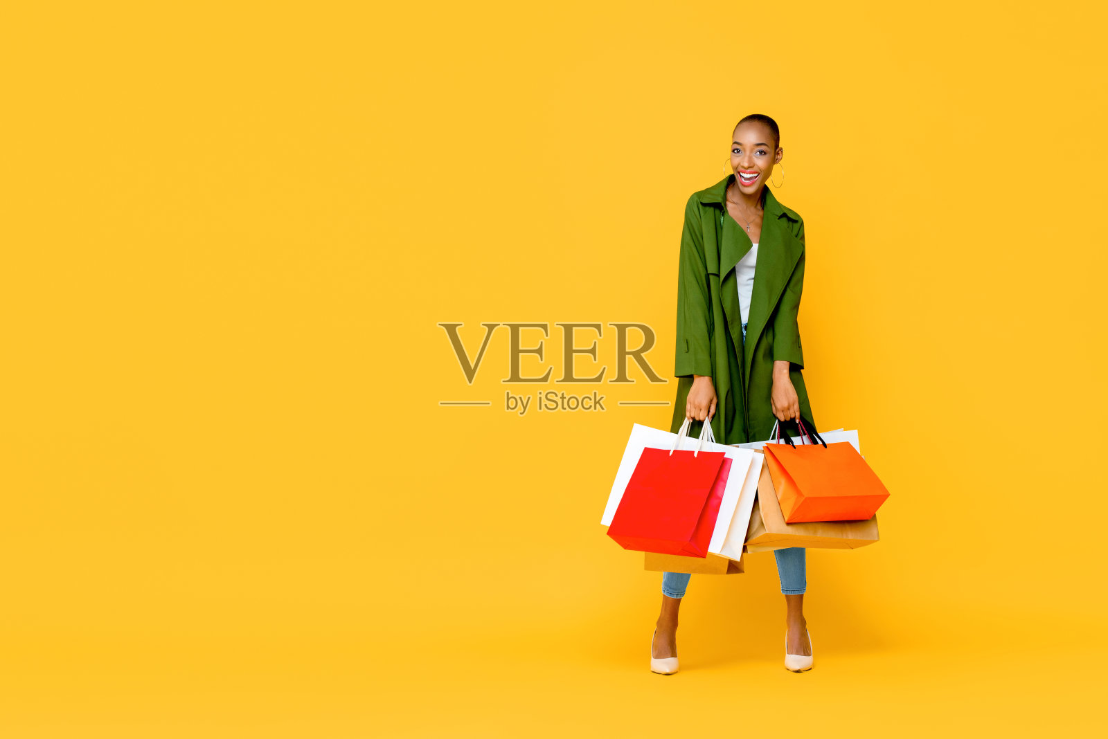 时尚的非洲裔美国妇女拿着五颜六色的购物袋照片摄影图片