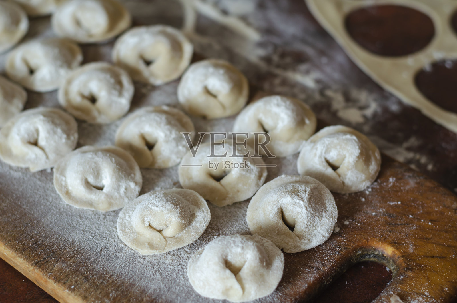 自制的食物。生饺子和肉放在木砧板上。照片摄影图片