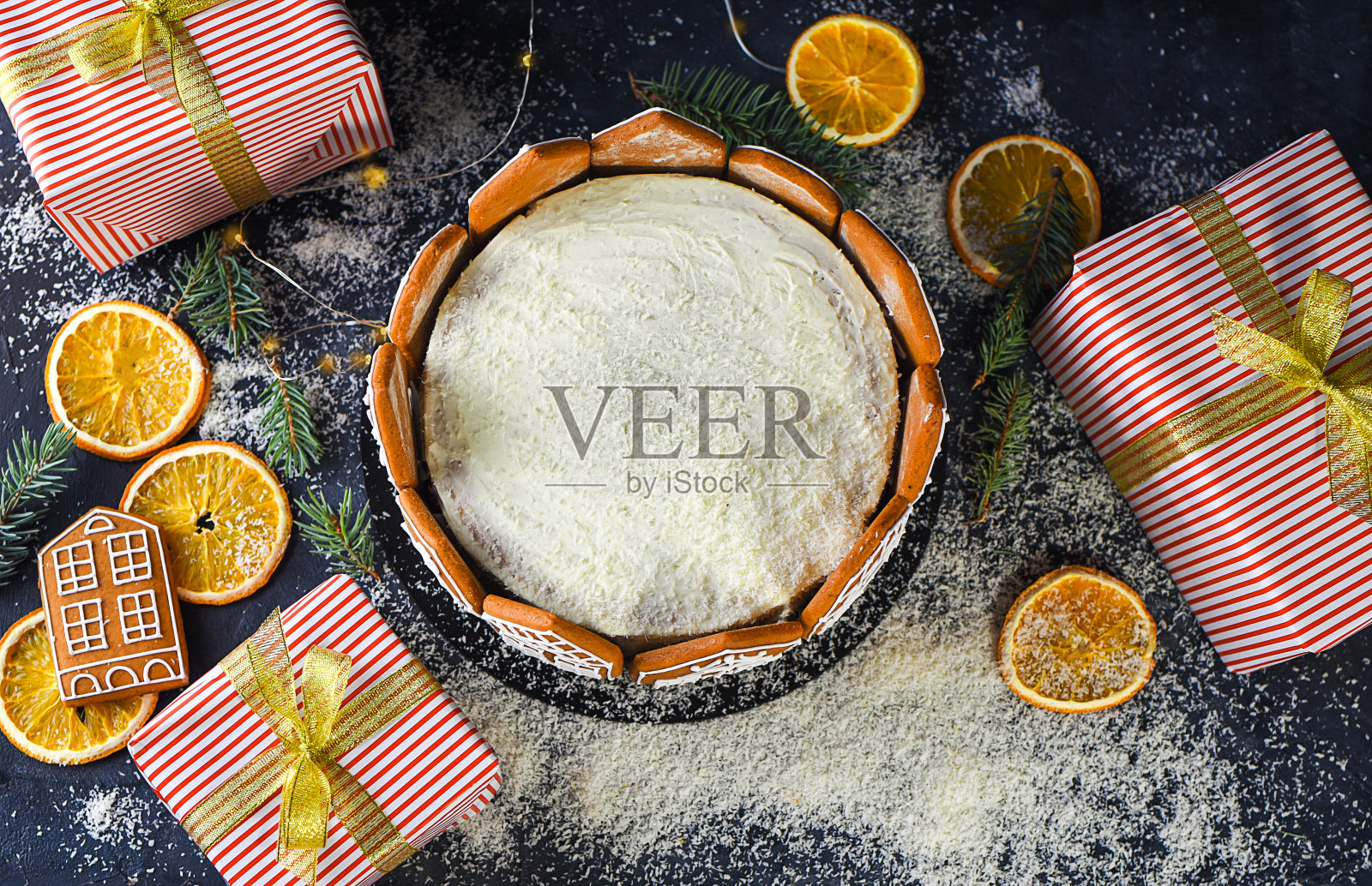 美丽而美味的饼干蛋糕与干橙子，肉桂棒，杉木棒，器具，姜饼的形式的房子。礼物。盒子。节日蛋糕。照片摄影图片