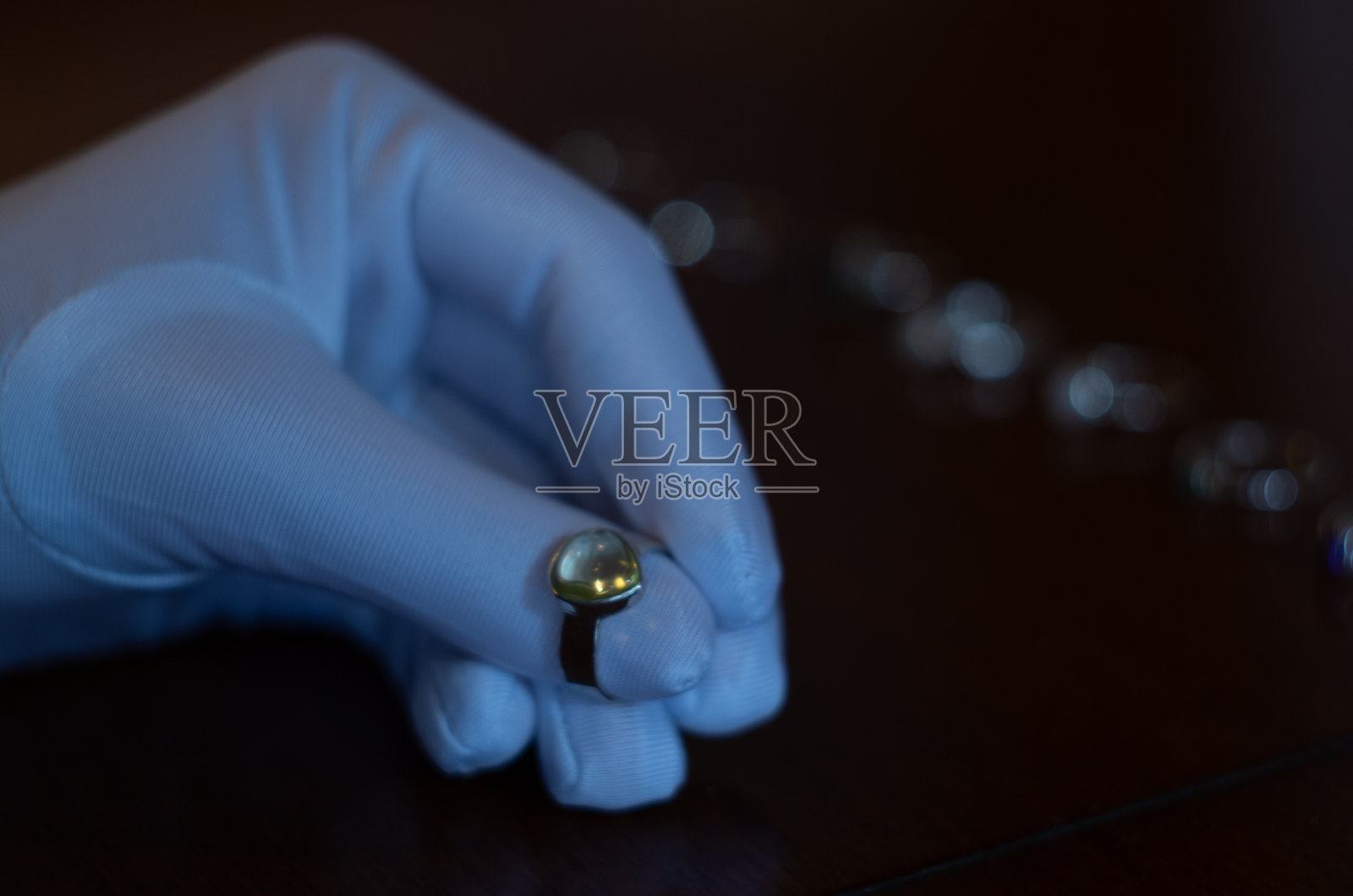 一位珠宝商戴着白手套检查着一件珠宝照片摄影图片