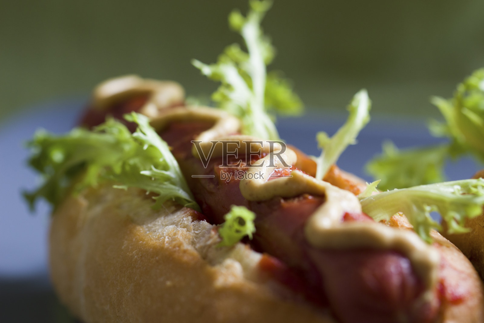 一份自制的经典热狗，配上黄芥末，番茄酱和新鲜的绿色沙拉。美国快餐。照片摄影图片