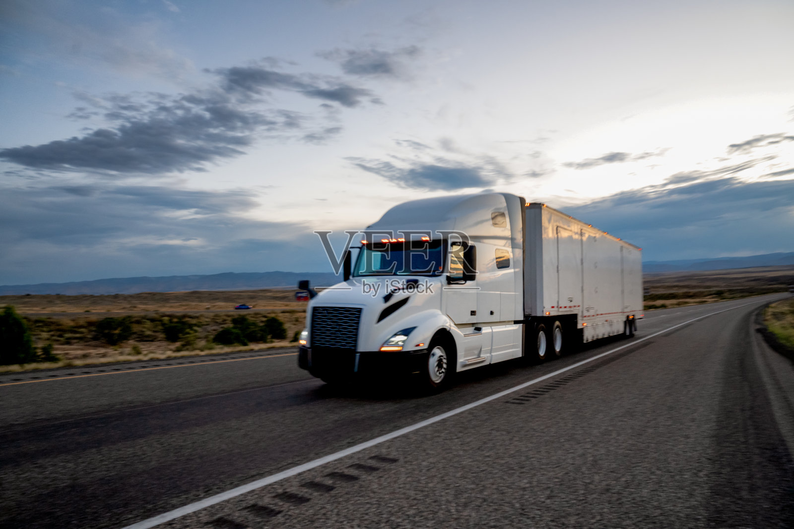 白色拖拉机，半挂车货运卡车在高速公路上滚动下一个戏剧性的天空照片摄影图片