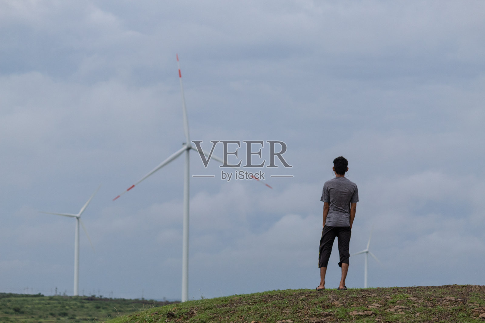 印度古吉拉特邦万卡内尔，一名印度男子站在风车前照片摄影图片