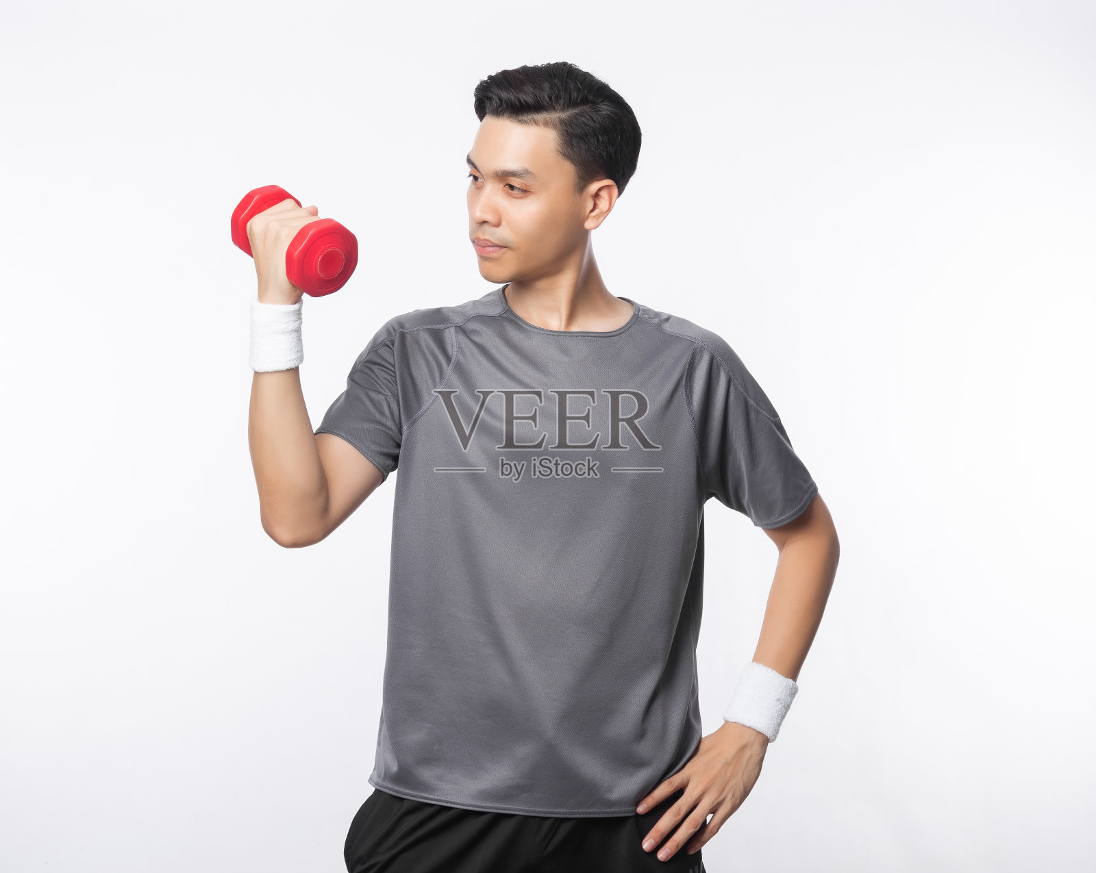 年轻英俊的亚洲男子在运动服装与哑铃孤立在白色背景照片摄影图片