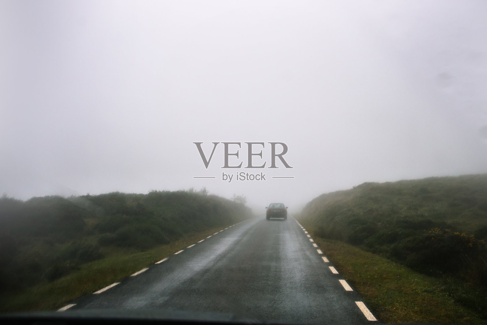 汽车在雾蒙蒙的路上行驶照片摄影图片