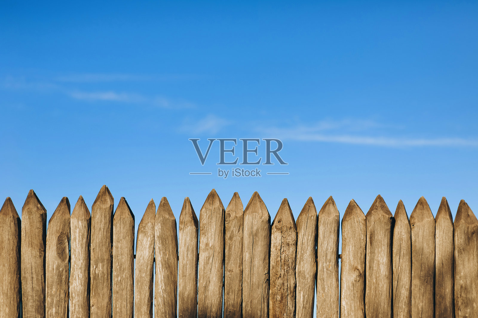 在蓝天的映衬下，用栅栏围起来。尖头圆木，古木纹理。副本的空间。Khortytsia, Zaporizhzhya西奇。照片摄影图片