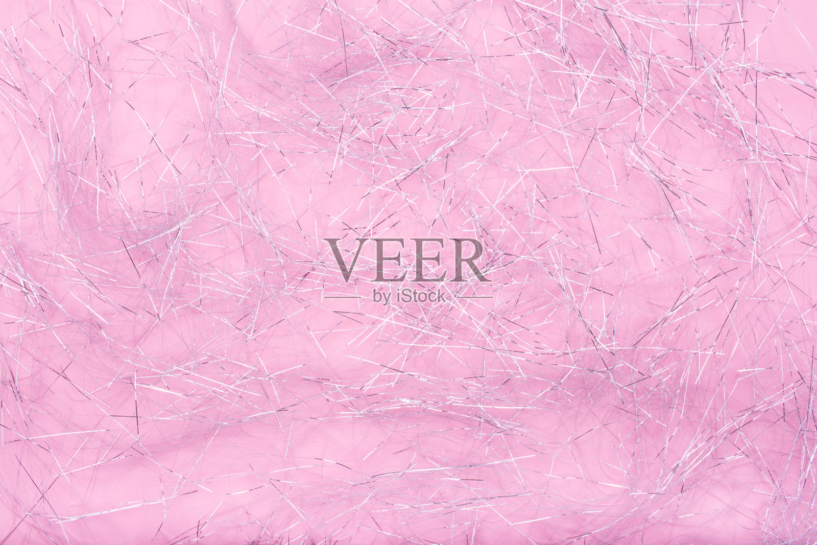 闪闪发光的碎片。闪闪发光的纸纹理为圣诞节。粉红色的背景上有银色的碎片。照片摄影图片