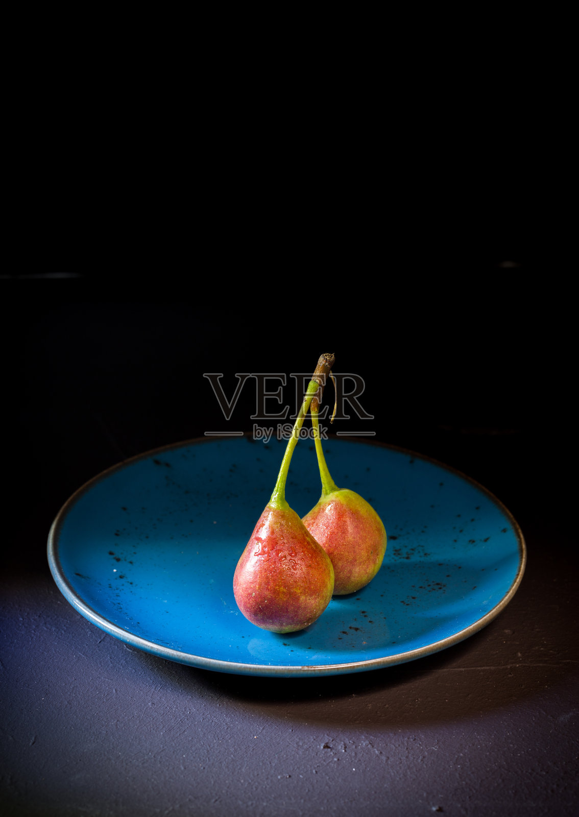 陈年的餐桌上，盘子里放着梨照片摄影图片