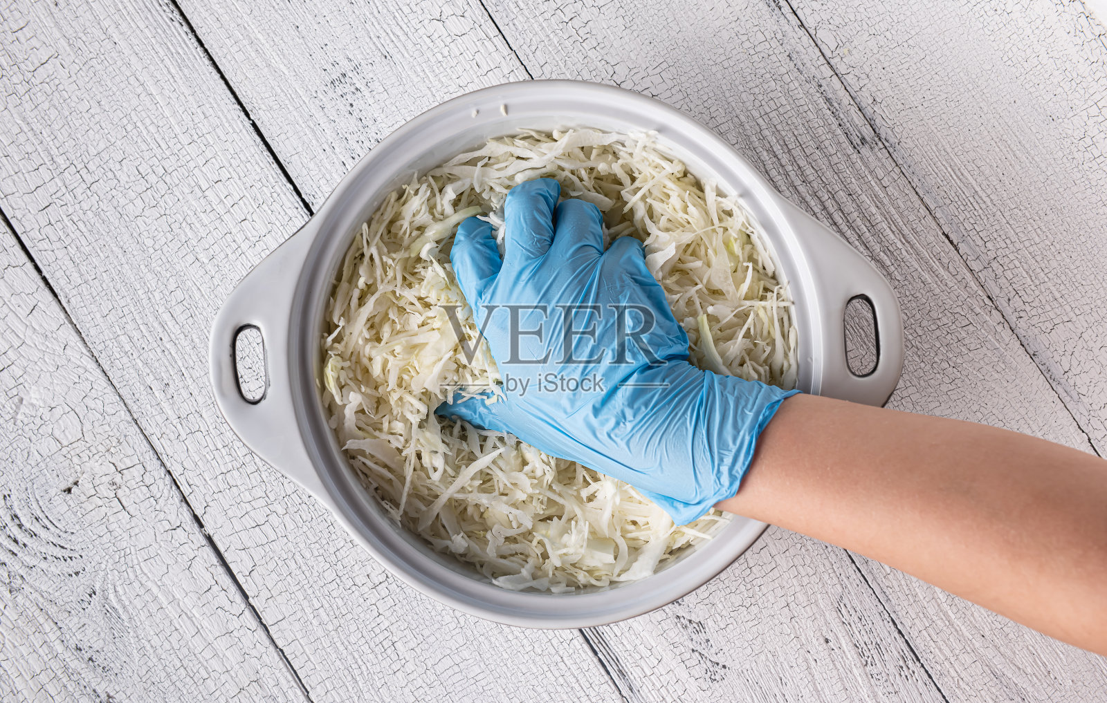 用手套挤碎卷心菜的少年的手照片摄影图片