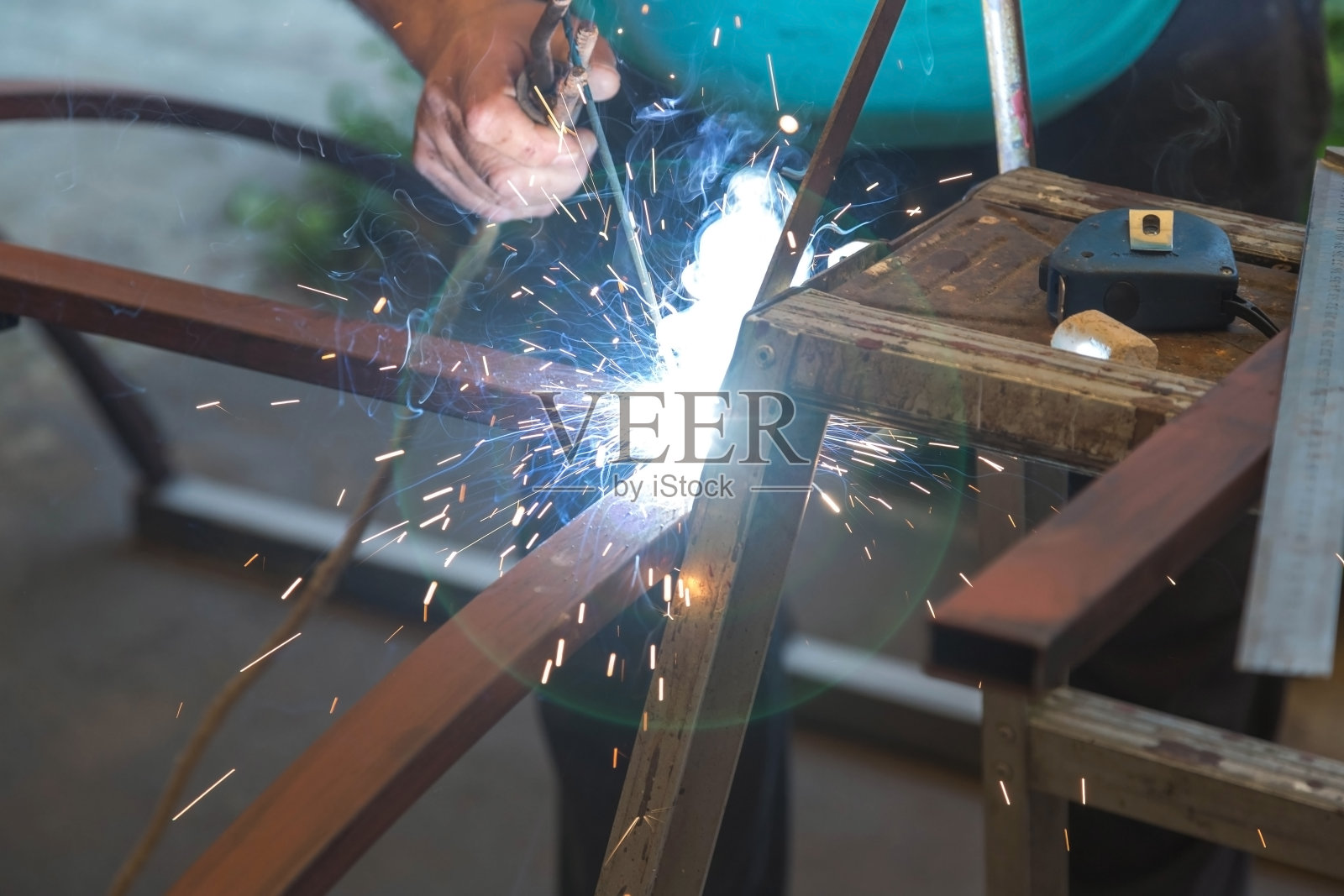 焊接的人工作业。灯,手册。焊工是焊接金属零件的。照片摄影图片