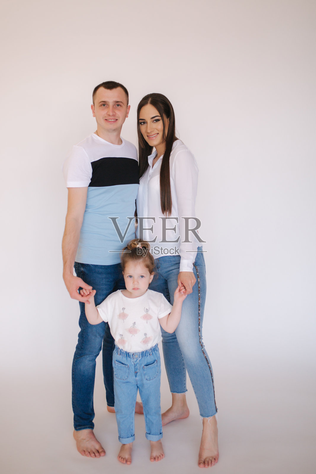 年轻的家庭在工作室。妈妈，爸爸和小女儿在休闲风格有照片照片摄影图片