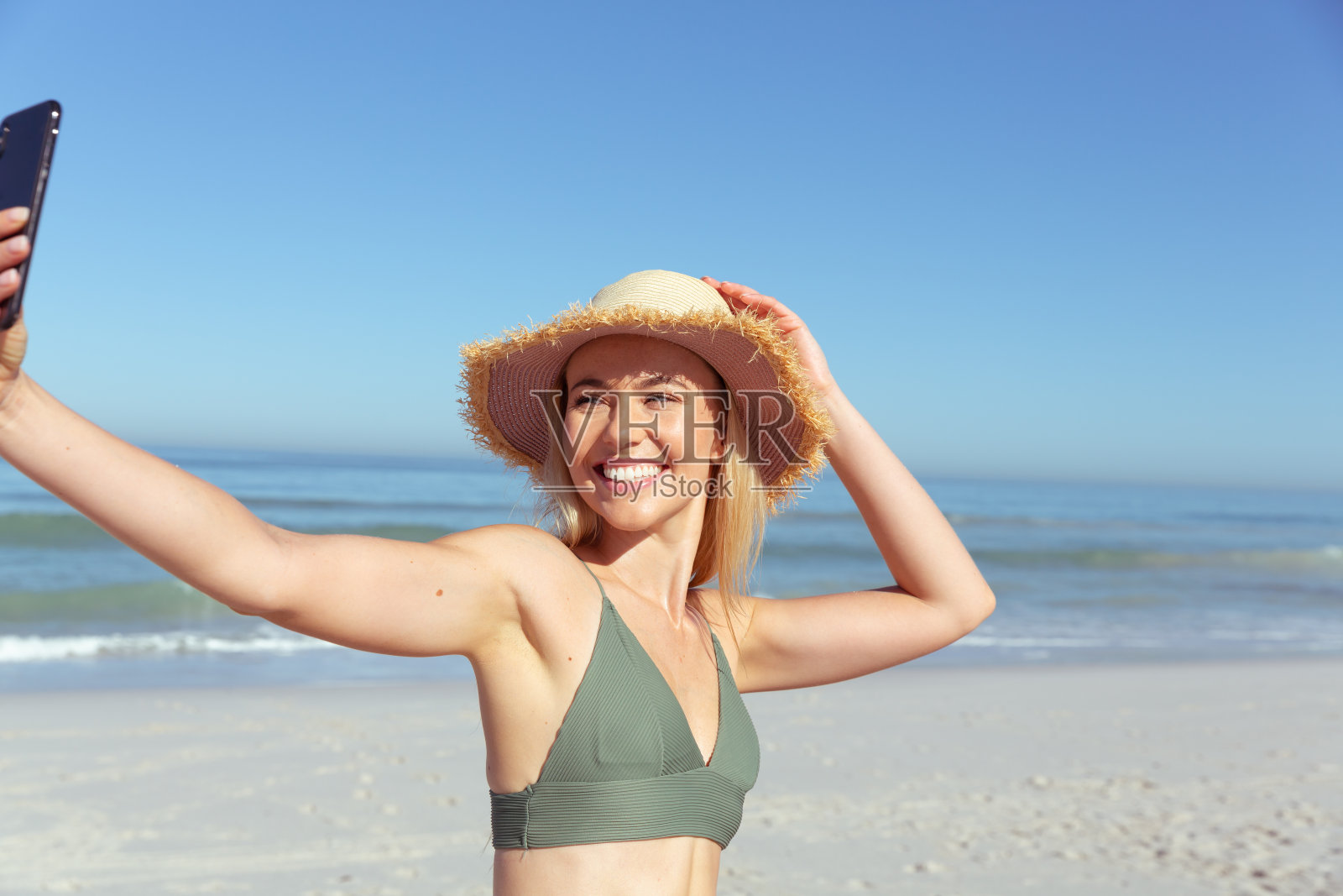 在海滩上自拍的女人微笑着照片摄影图片