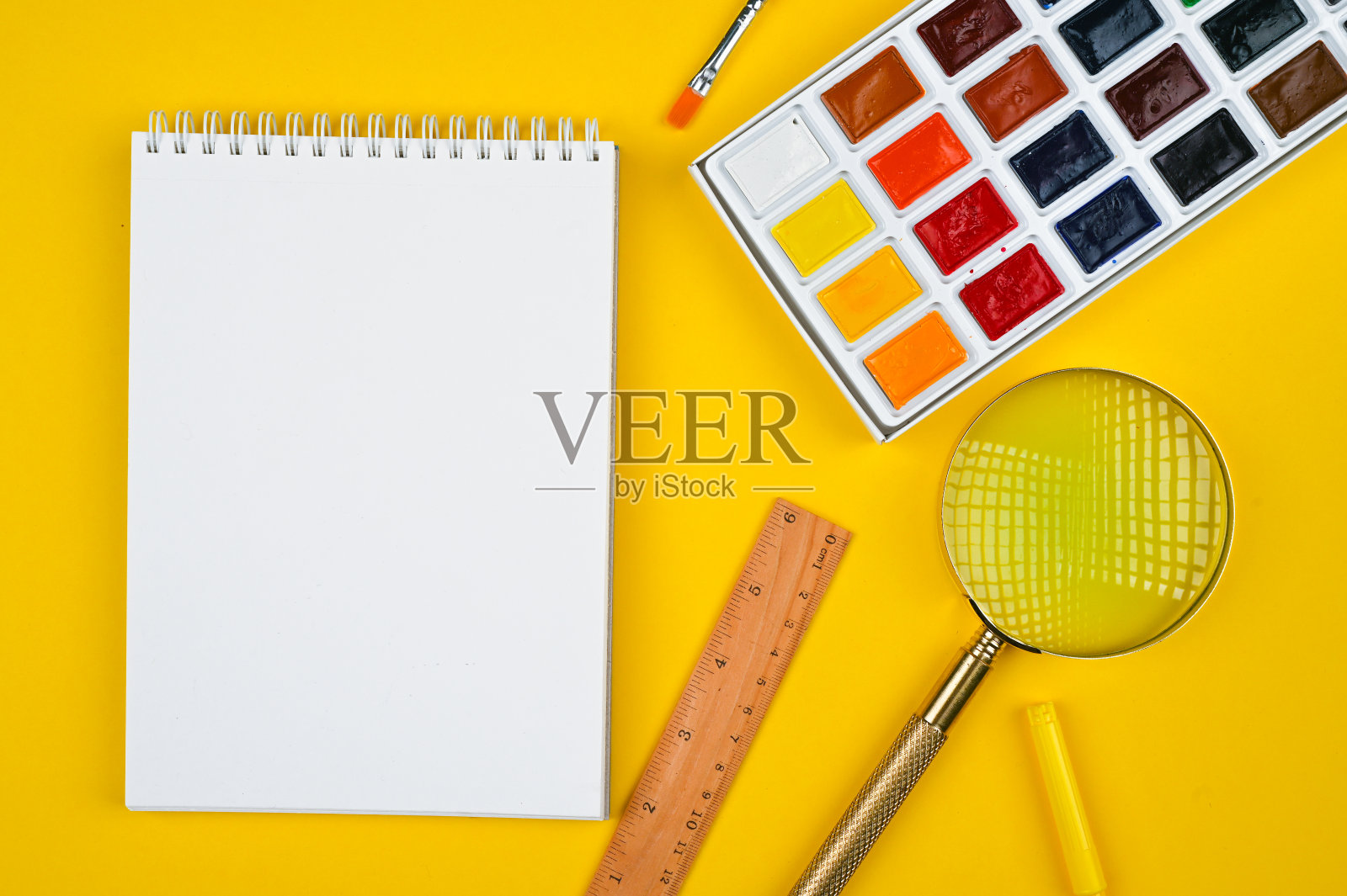 不同颜色的学习用品在黄色纸背景照片摄影图片
