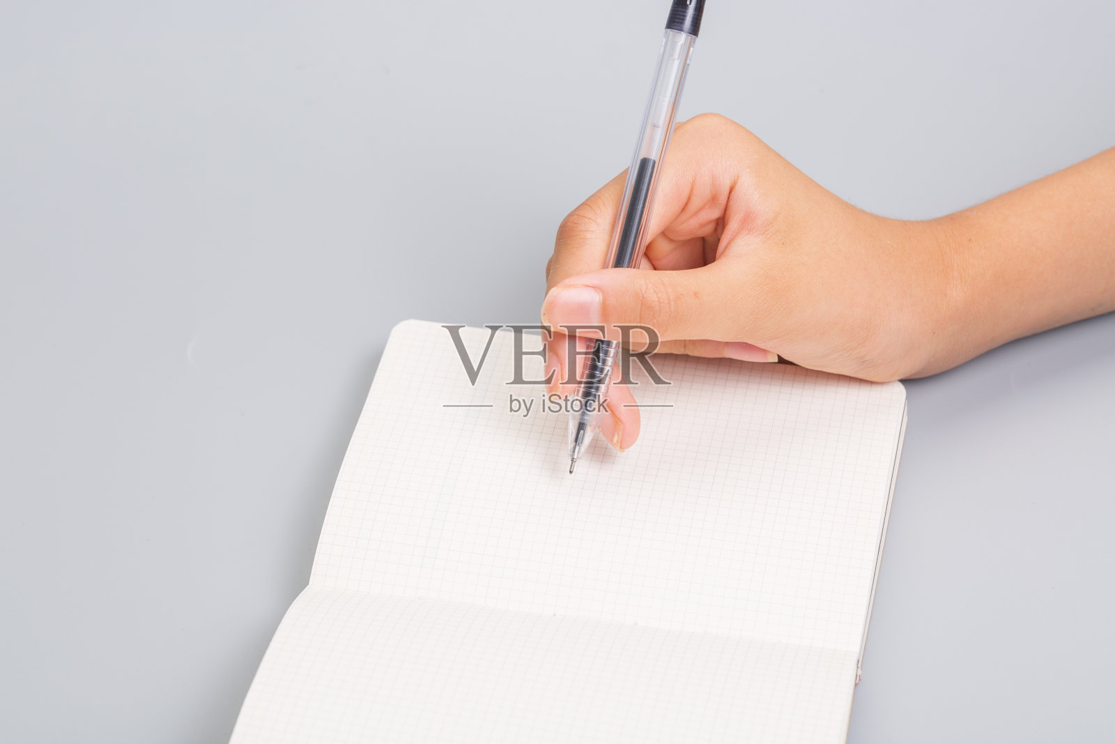 网格笔记本，手里拿着铅笔照片摄影图片