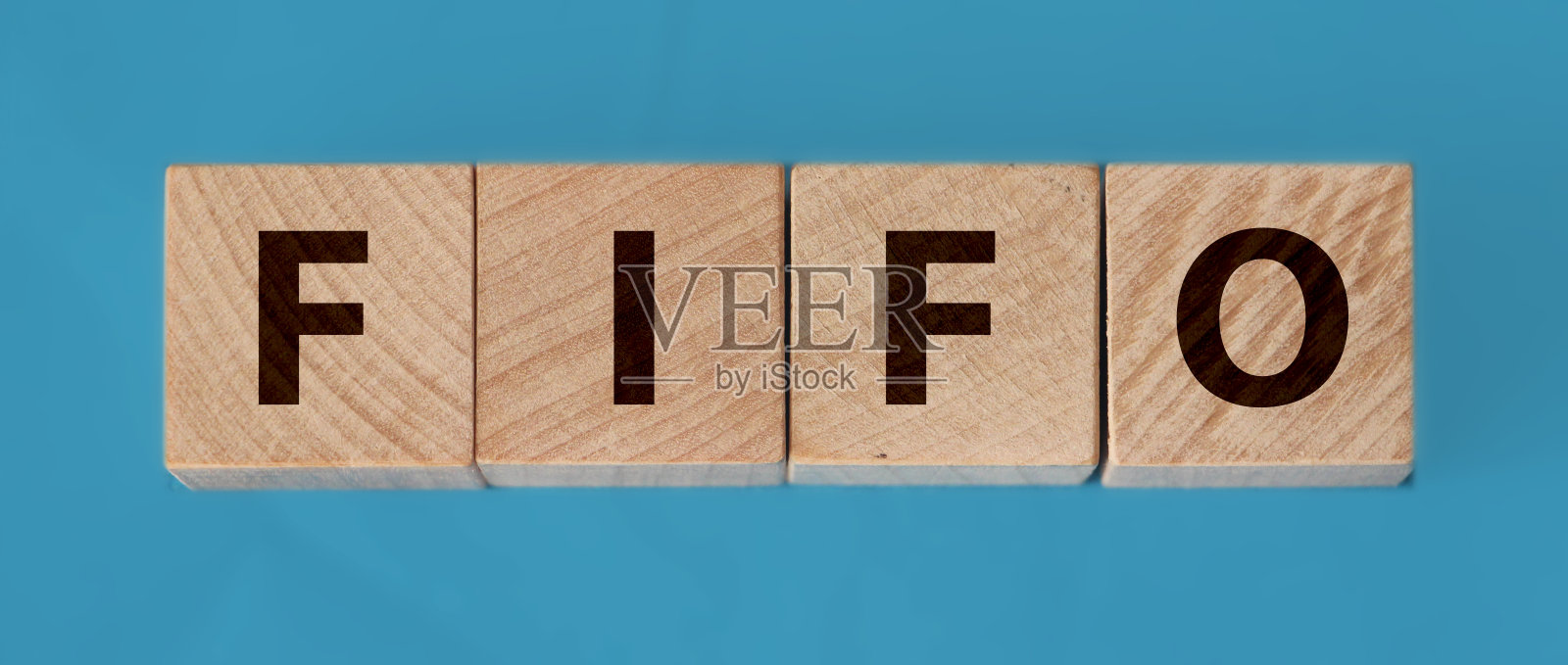 先进先出会计概念，木制方块，蓝色背景照片摄影图片