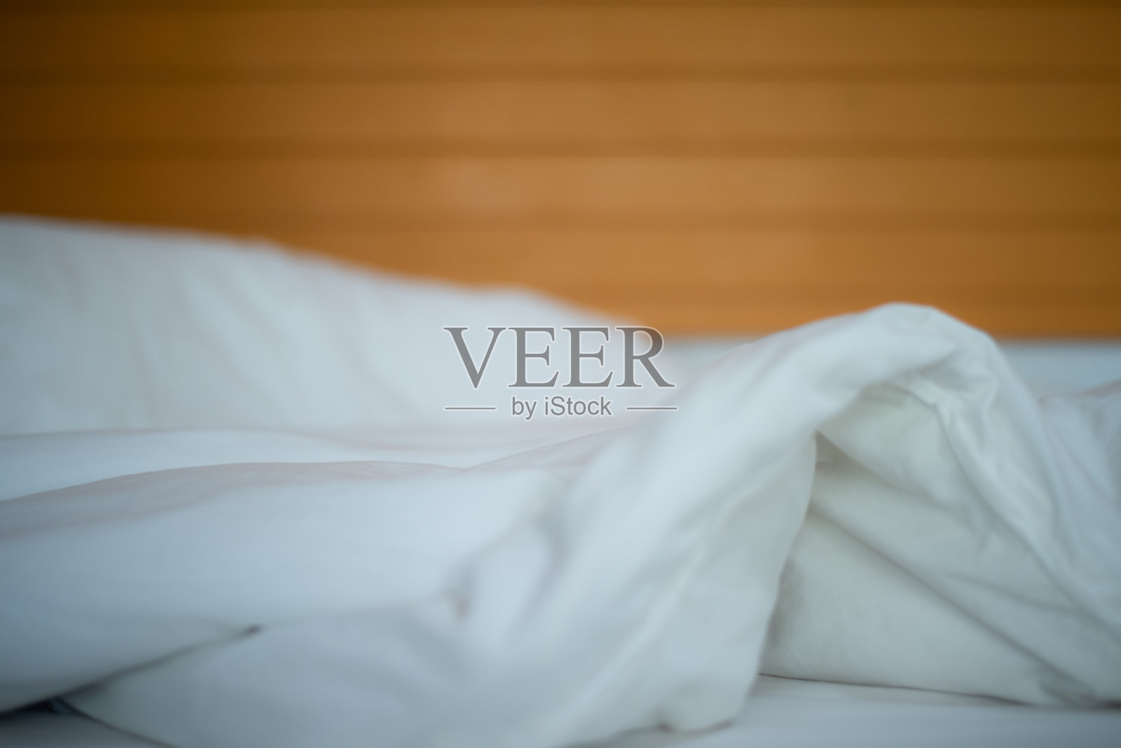 迷离的人睡在白色的卧室里。照片摄影图片