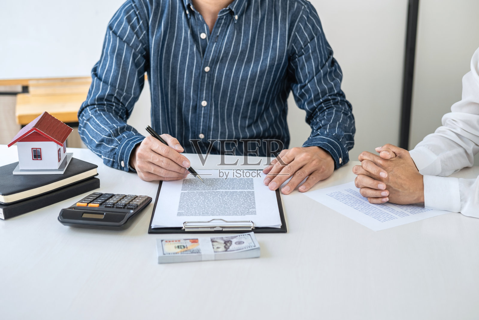 房地产经纪人在分析并做出决定后，决定向客户发放房地产贷款，签订购房合同文件，银行员工推荐按揭贷款审批照片摄影图片
