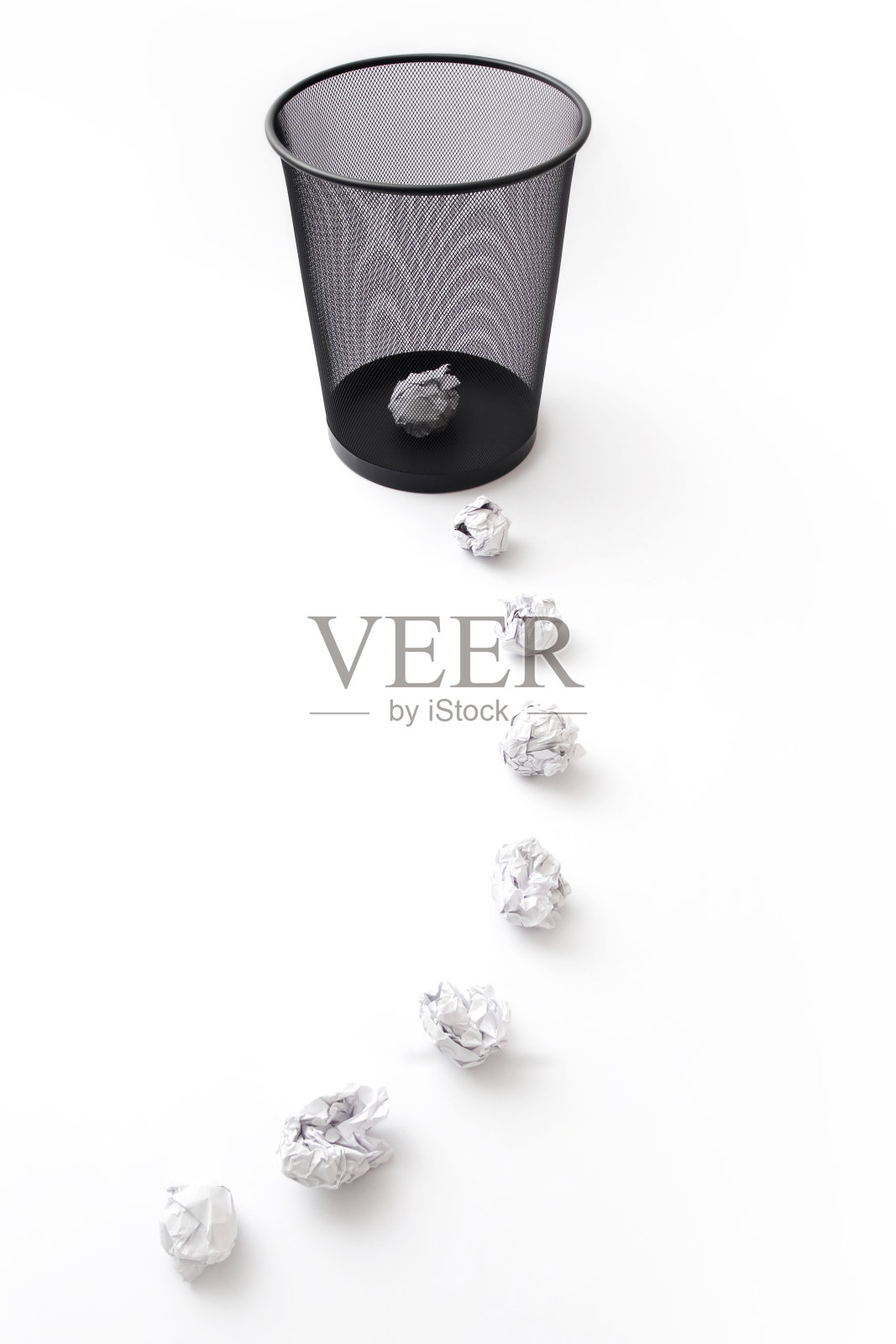 一堆皱巴巴的纸通向垃圾桶里的一张皱巴巴的纸照片摄影图片