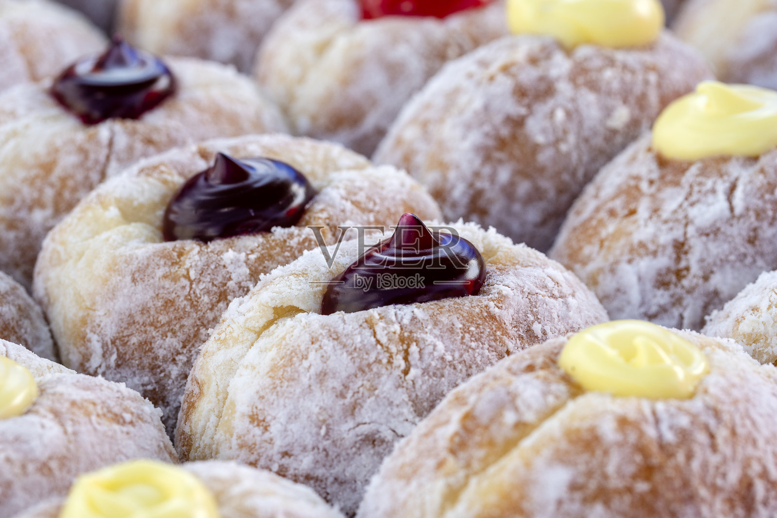 泰国街头小吃市场的甜甜圈，特写。美味的果酱、巧克力和炼乳甜甜圈照片摄影图片