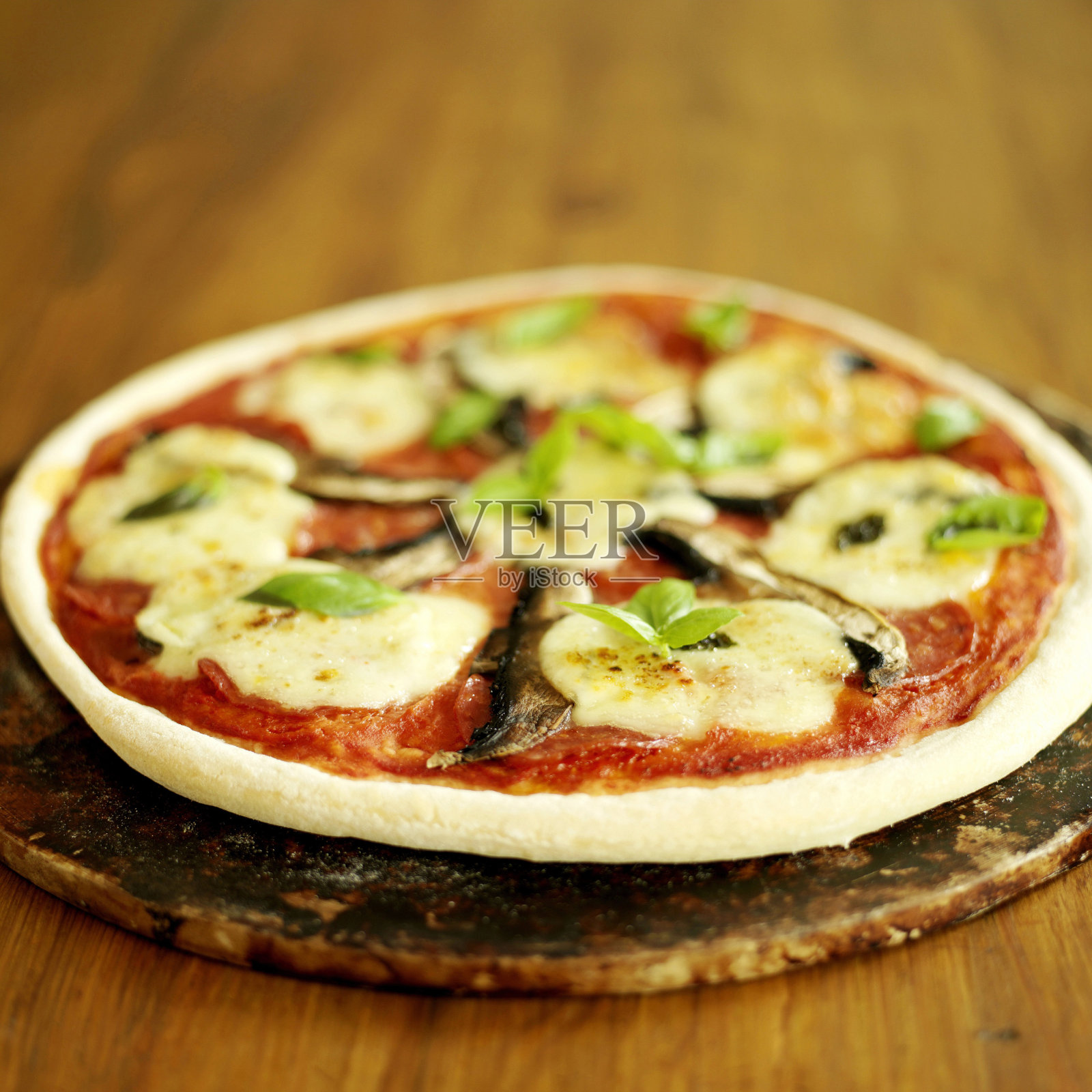 刚烤好的披萨坐在披萨石上照片摄影图片