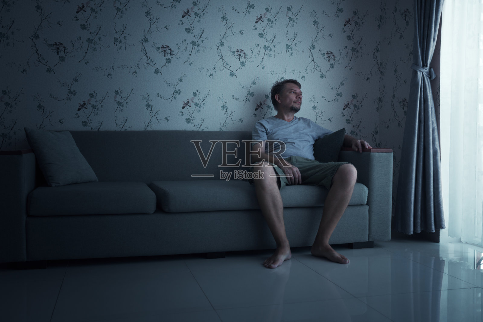 隔离期间坐在沙发上的无聊男子照片摄影图片