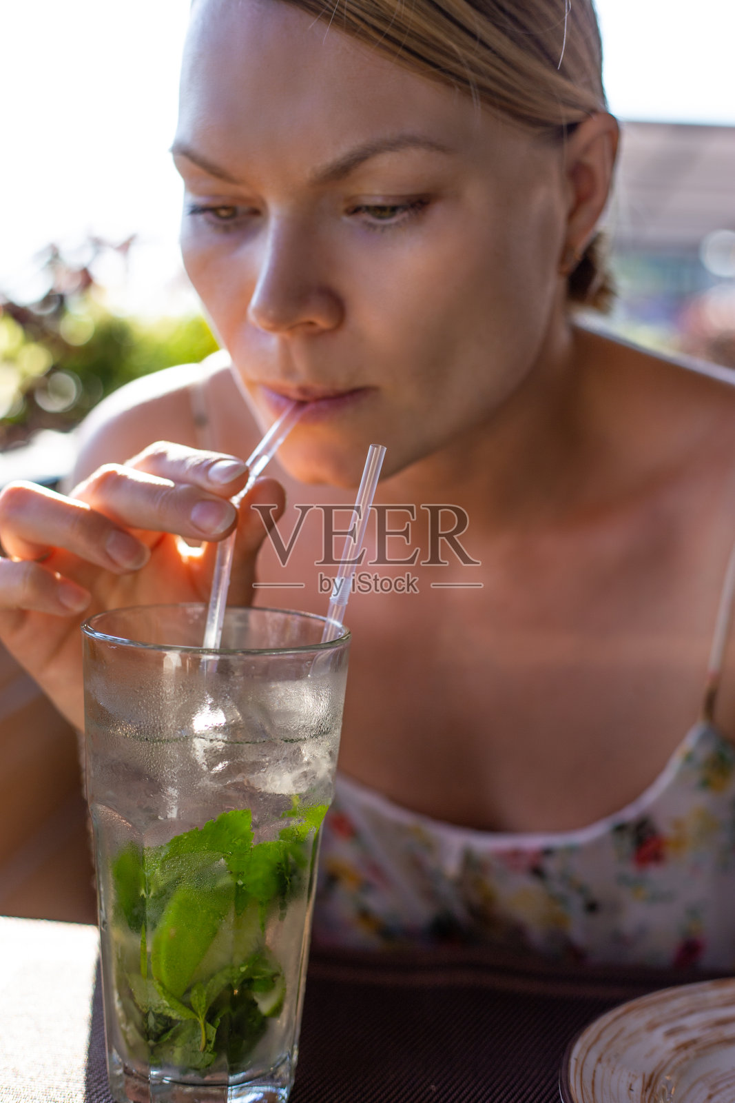 美丽的女孩在咖啡馆喝着莫吉托照片摄影图片